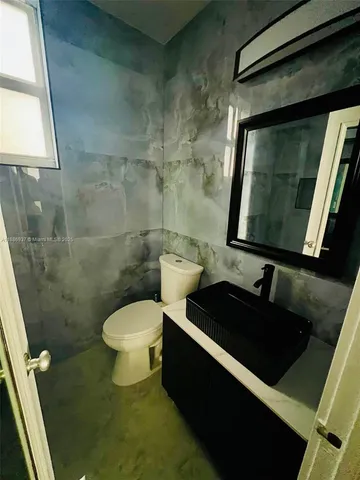 a bathroom with a toilet a sink and mirror