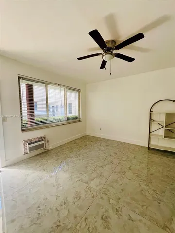 a view of a kitchen with refrigerator and white cabinets
