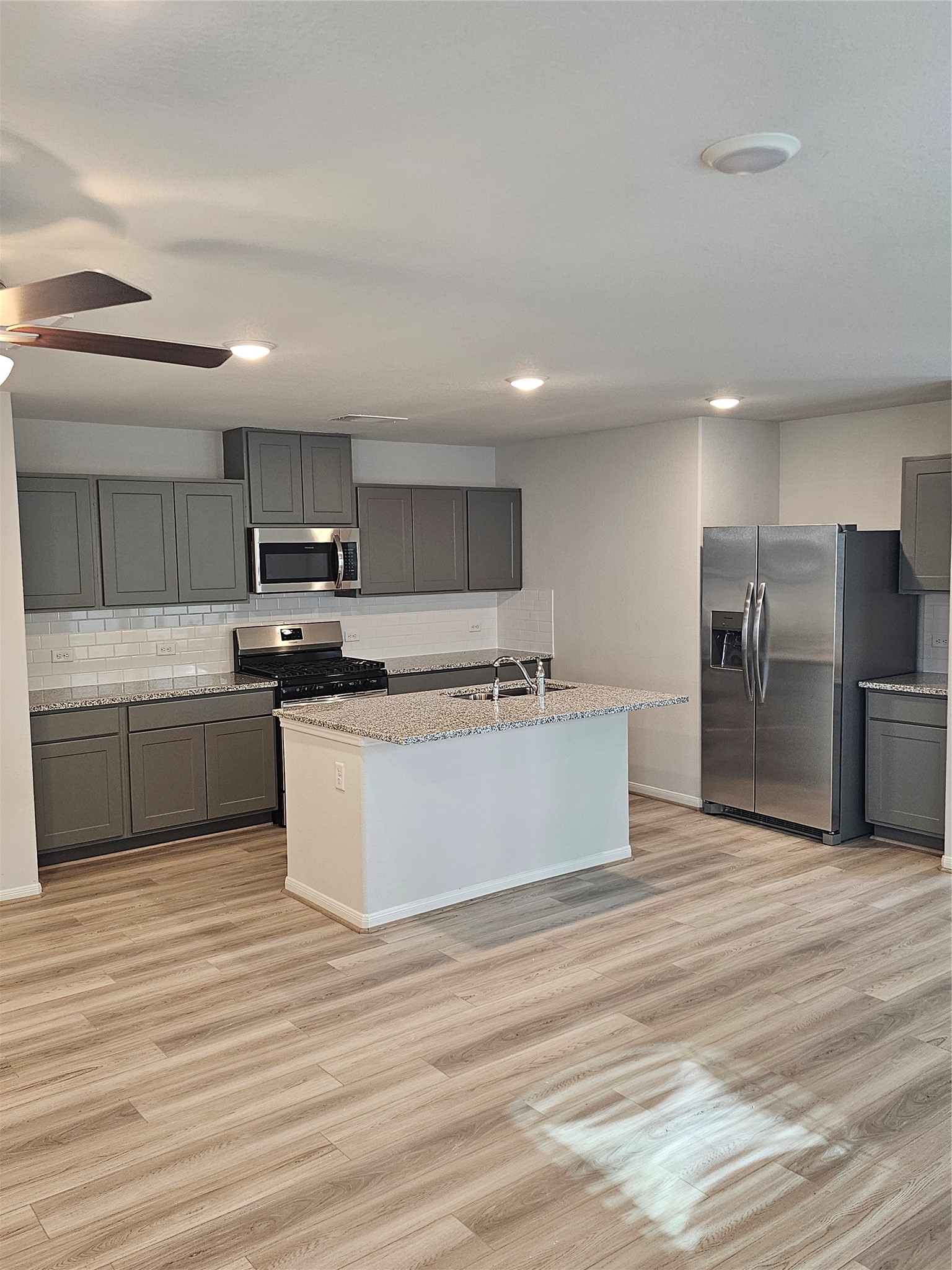 5207 Shallowhurst Lane Katy, TX 77449 - Photo 15 of 27 a large kitchen with kitchen island a sink a center island stainless steel appliances and a counter space
