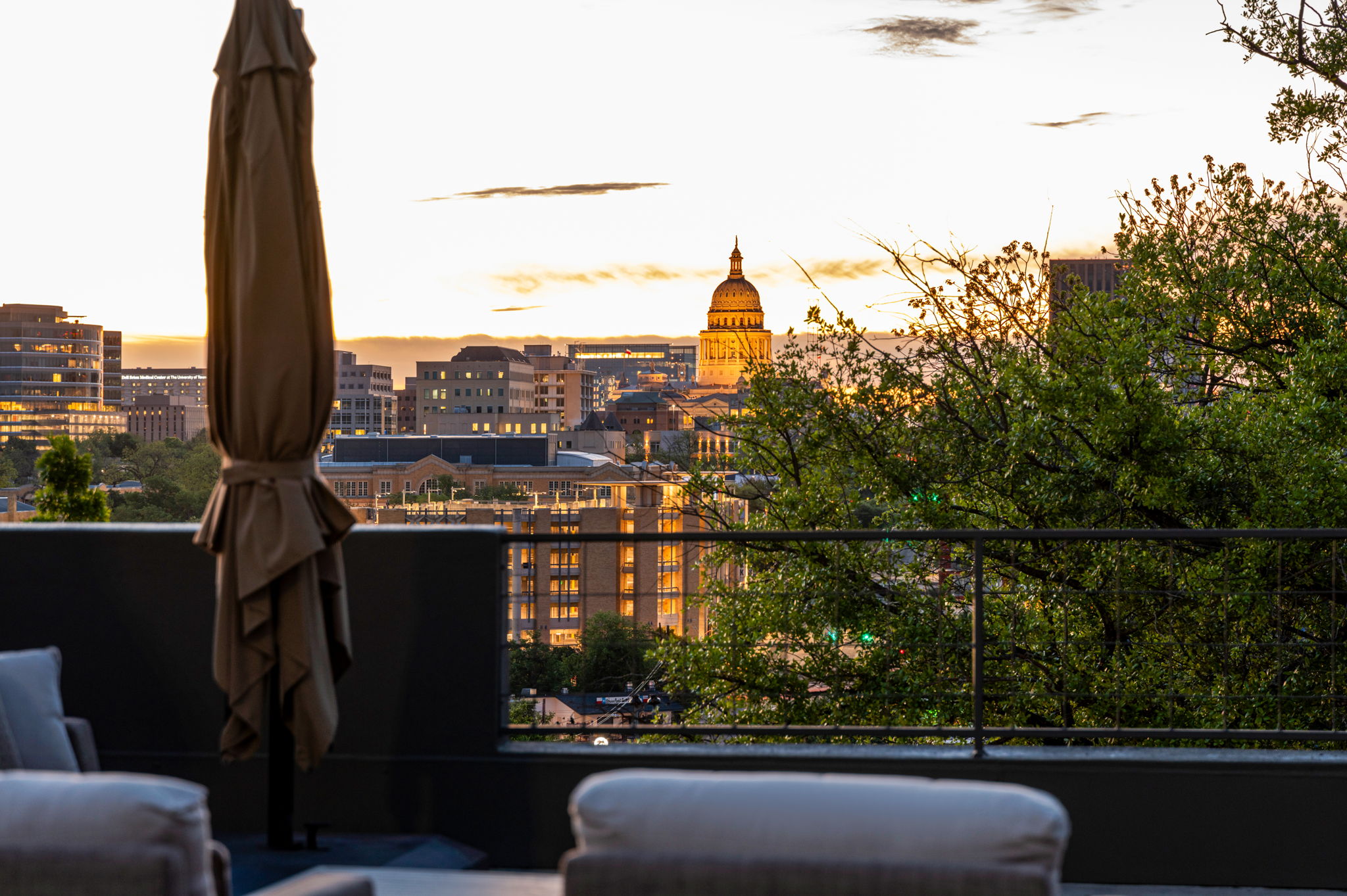 1111 West 12th Street, Unit 107 Austin, TX 78703 - Photo 12 of 38 Rooftop terrace featuring a dark gray parapet wall, black metal railing, and distant cityscape with a prominent dome structure