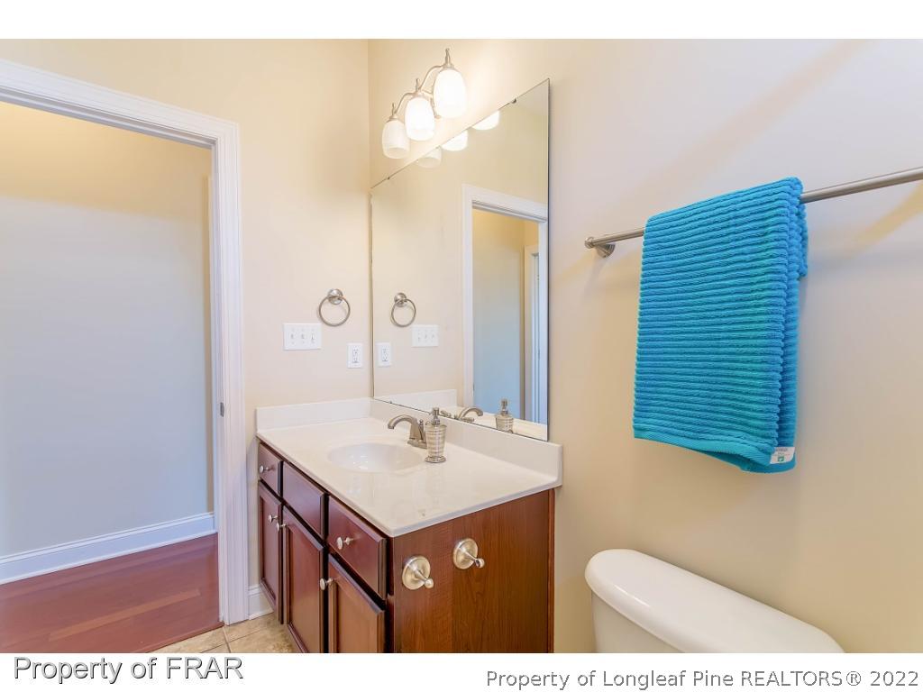 409 St Johns Loop Raeford, NC 28376 - Photo 11 of 36 a bathroom with a sink a mirror and a toilet