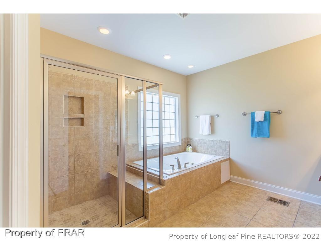 409 St Johns Loop Raeford, NC 28376 - Photo 26 of 36 a bathroom with a tub sink and mirror