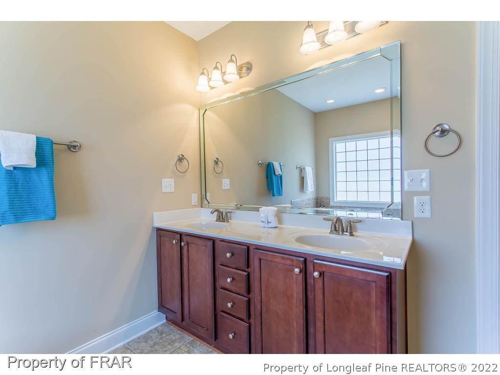 409 St Johns Loop Raeford, NC 28376 - Photo 29 of 36 a bathroom with a granite countertop sink a mirror and a