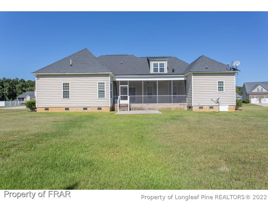 409 St Johns Loop Raeford, NC 28376 - Photo 4 of 36 a front view of a house with a yard and potted plants
