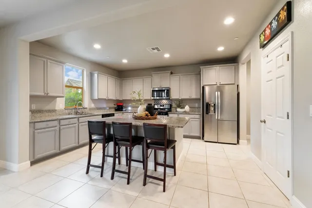 a kitchen with kitchen island granite countertop wooden cabinets a center island and stainless steel appliances