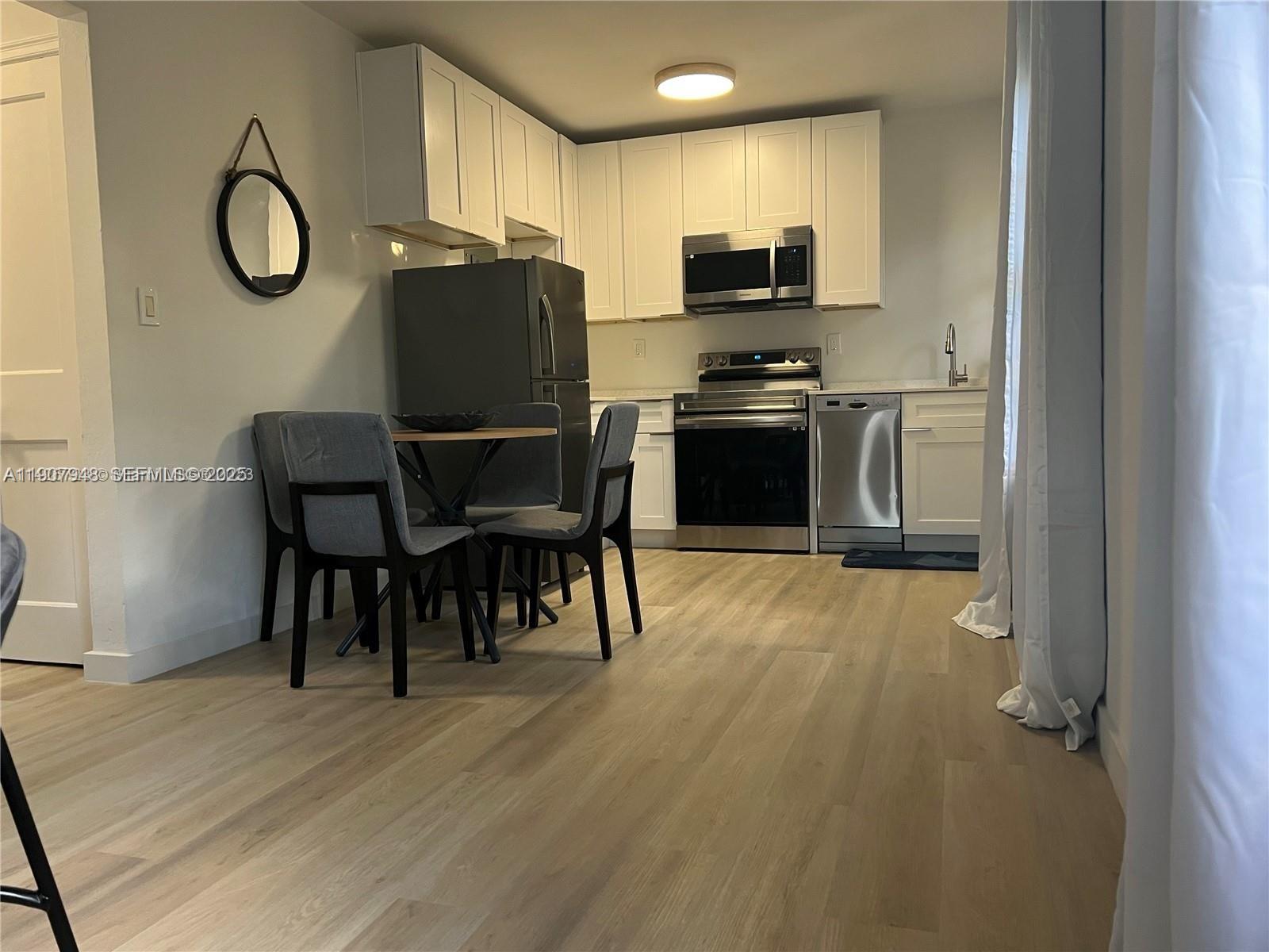 421 75th Street, Unit 3 Miami Beach, FL 33141 - Photo 4 of 21 a kitchen with stainless steel appliances granite countertop a stove top oven a sink and a refrigerator