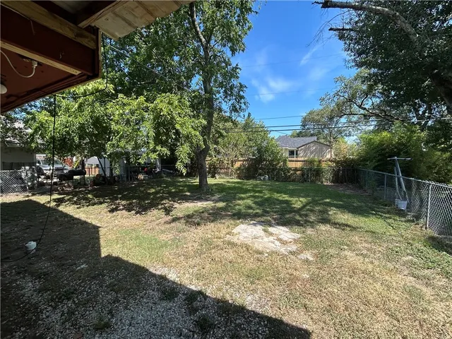 a view of a yard with plants and a lake view