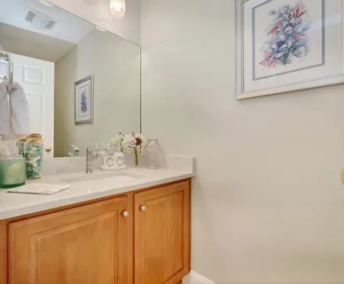 a bathroom with a granite countertop sink a mirror and a picture on the wall