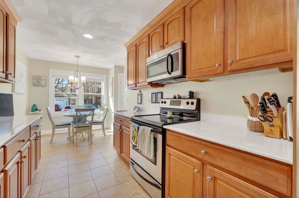102 Central Street, Unit 5A Saugus, MA 01906 - Photo 3 of 31 a kitchen with stainless steel appliances granite countertop a stove a sink and a microwave