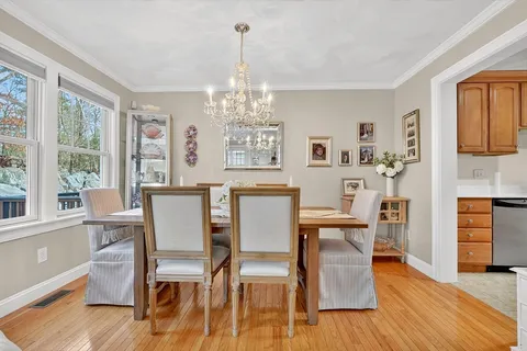 a view of a dining room with furniture a chandelier and wooden floor