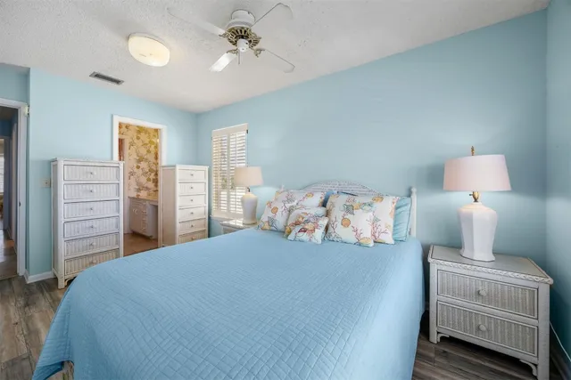 a bedroom with bed and three large window