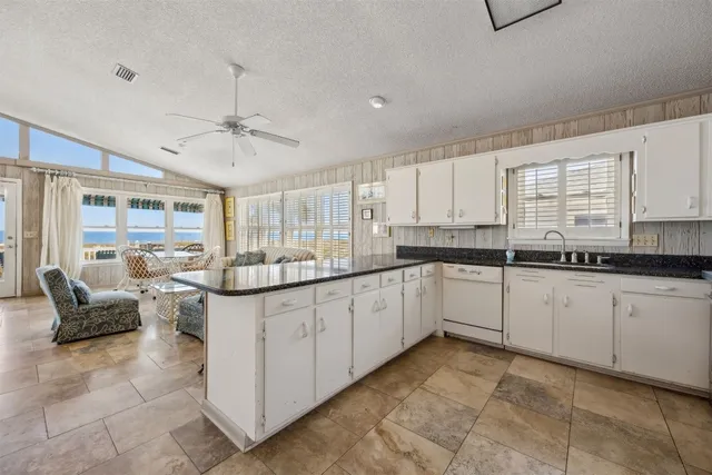 a kitchen with granite countertop white cabinets and white appliances