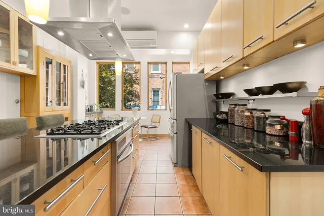 a kitchen with stainless steel appliances granite countertop a sink and a stove