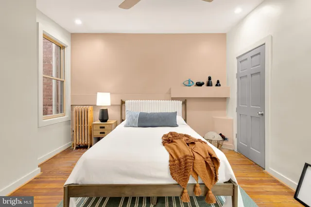 a bedroom with bed and wooden floor