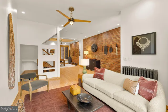 a living room with furniture and a ceiling fan