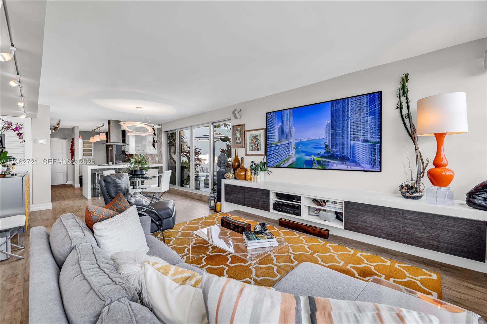680 Northeast 64th Street, Unit APH3 Miami, FL 33138 - Photo 23 of 77 a living room with furniture a flat screen tv and kitchen view