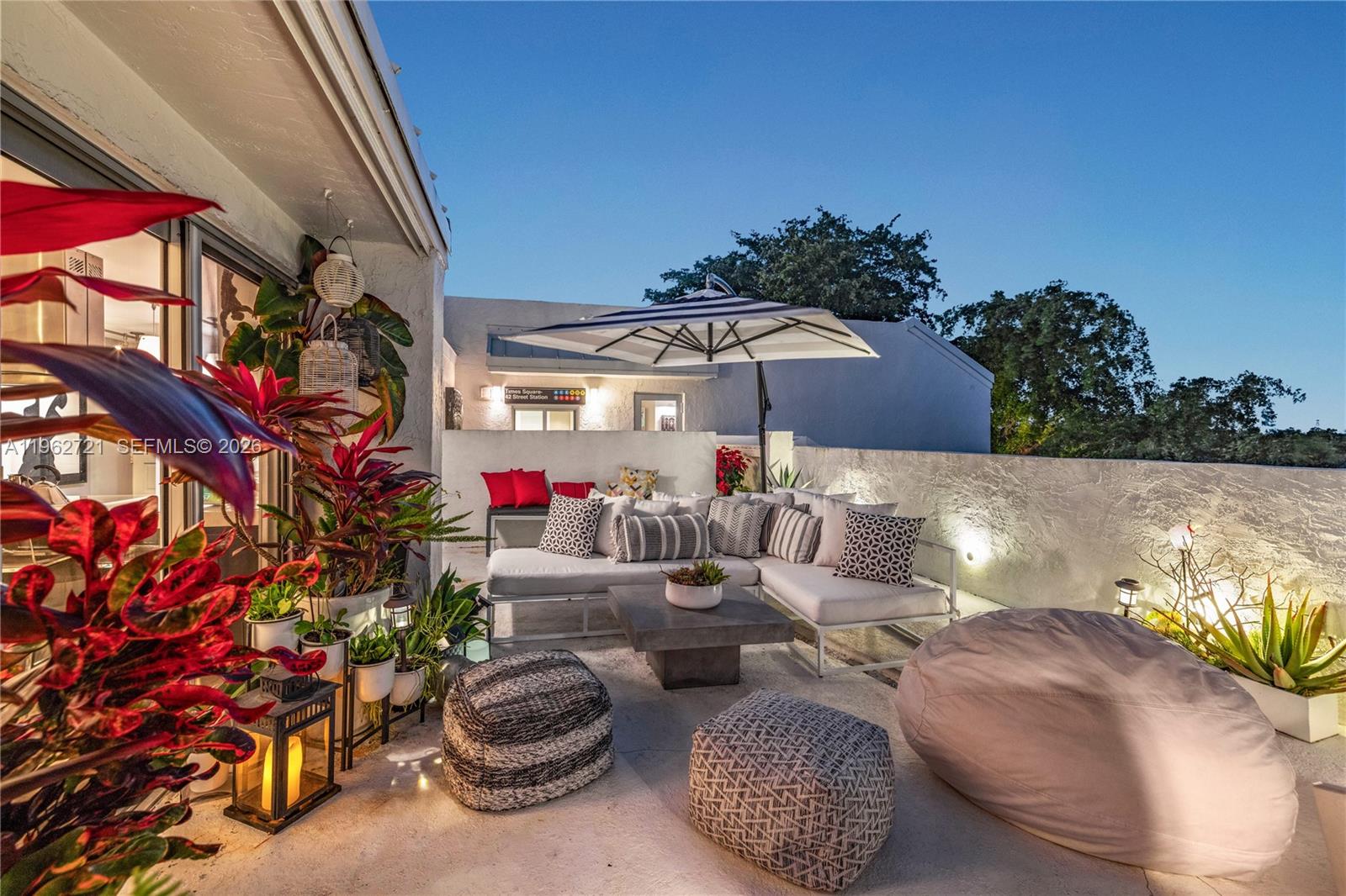 680 Northeast 64th Street, Unit APH3 Miami, FL 33138 - Photo 3 of 77 a view of a patio with couches and table and chairs and potted plants
