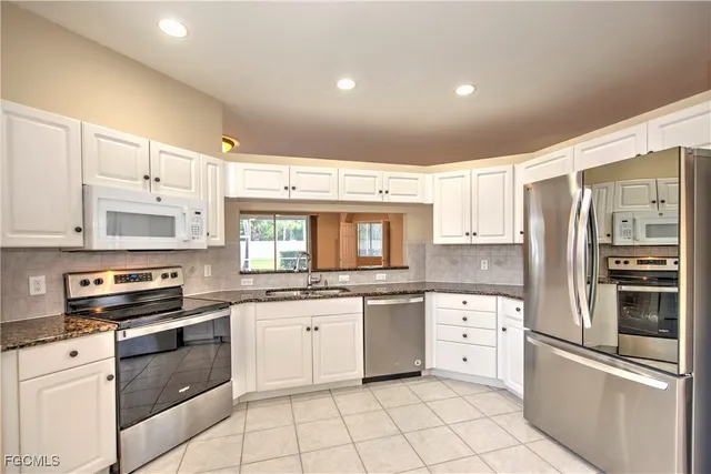 a kitchen with stainless steel appliances and white cabinets