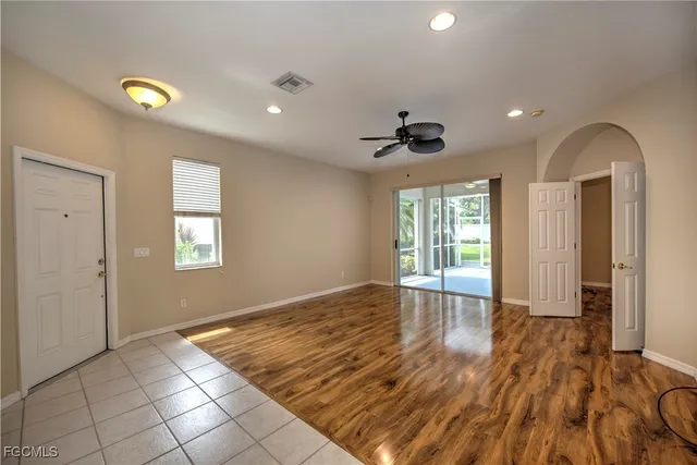 a view of an empty room with glass door and wooden floor
