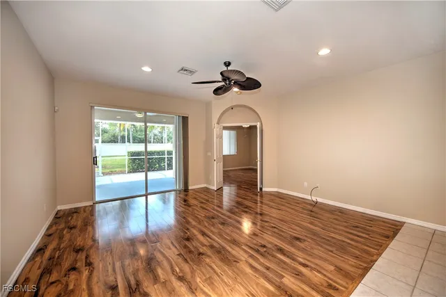 a view of an empty room with a window and wooden floor