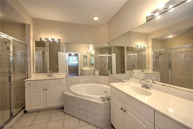 a bathroom with a tub a sink shower and mirror