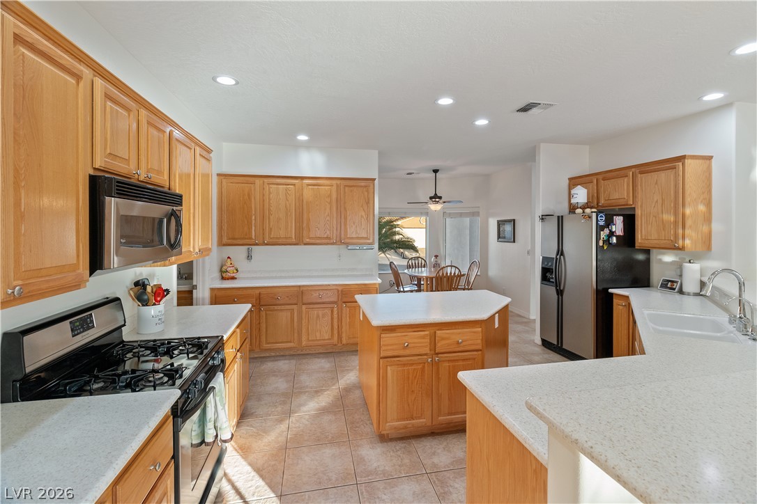 3505 Cottage Meadow Way Laughlin, NV 89029 - Photo 3 of 98 The Kitchen has long countertops, stainless steel appliances, tile flooring, and wood cabinetry.