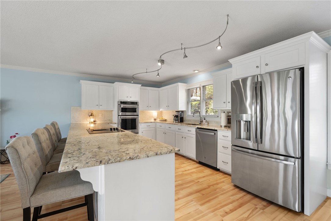 1002 Whitfield Point Road Anderson, SC 29626 - Photo 23 of 49 This bright kitchen features wood flooring and a large island, perfect for gathering.