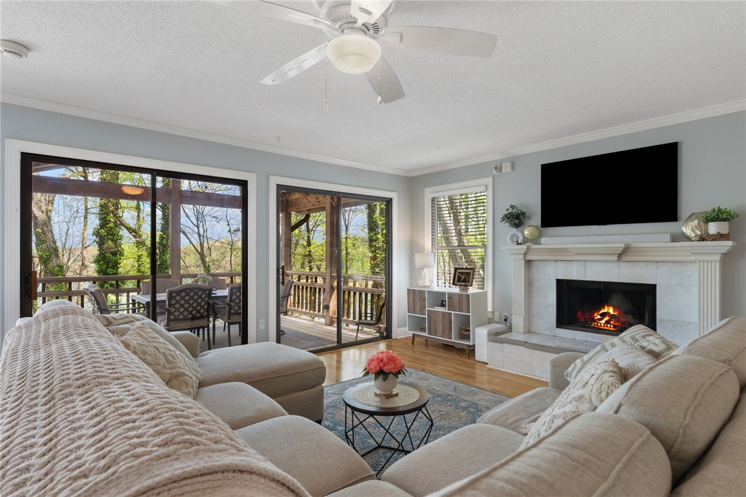 1002 Whitfield Point Road Anderson, SC 29626 - Photo 28 of 49 This living room offers seamless indoor-outdoor living with a cozy fireplace and expansive deck access.