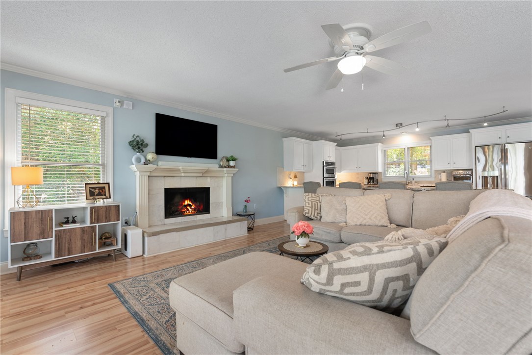 1002 Whitfield Point Road Anderson, SC 29626 - Photo 29 of 49 This inviting space features a cozy fireplace, seamlessly connecting to an open-concept kitchen.
