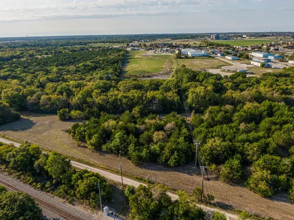 an aerial view of residential houses with outdoor space and trees