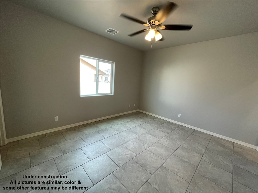 3591 North Verdugo Road Kingman, AZ 86409 - Photo 12 of 19 Spacious room featuring tile flooring, a window providing natural light, and a ceiling fan with integrated lighting