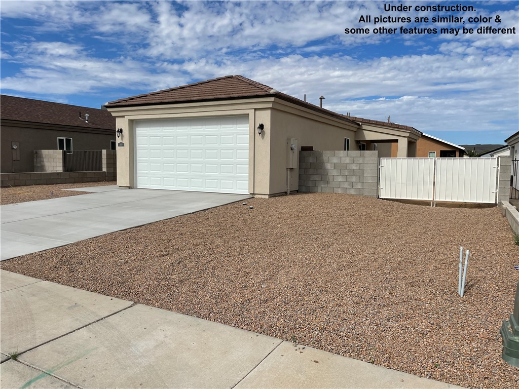 3591 North Verdugo Road Kingman, AZ 86409 - Photo 4 of 19 The property features a concrete driveway leading to an attached garage with a white sectional door