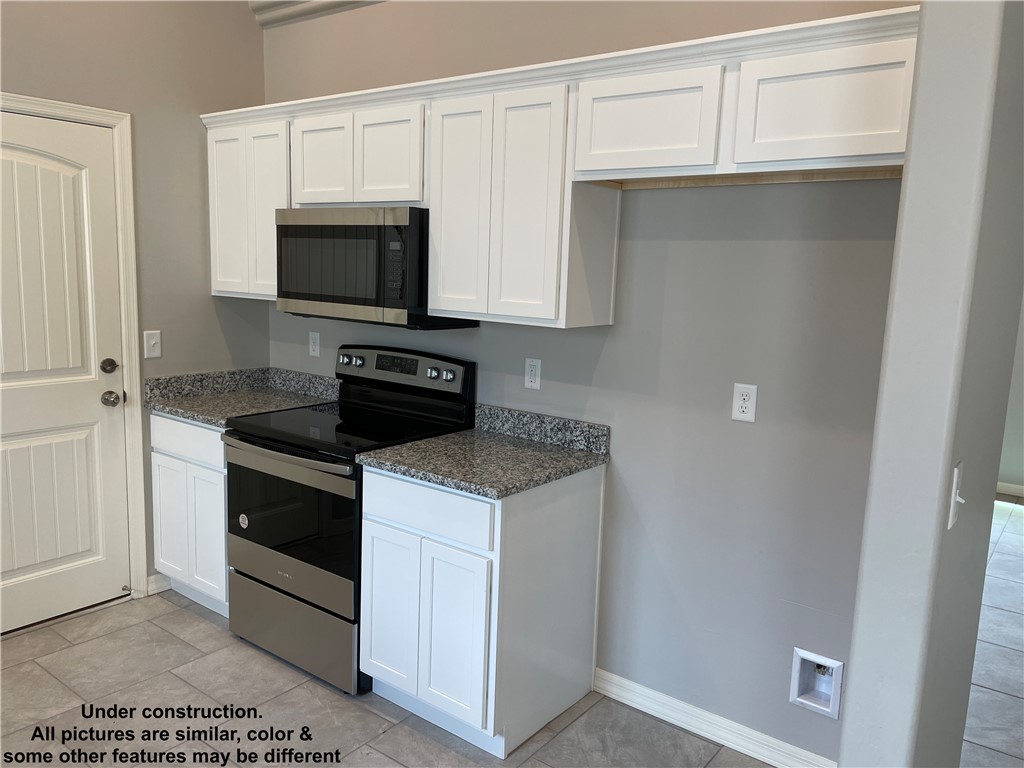 3591 North Verdugo Road Kingman, AZ 86409 - Photo 9 of 19 Kitchen featuring white cabinetry, granite countertops, a stainless steel microwave, and a stainless steel electric range