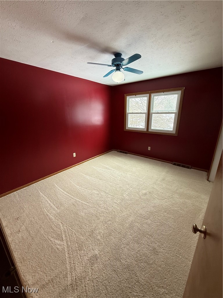 8335 Shepard Road Macedonia, OH 44056 - Photo 11 of 17 Spare room featuring carpet flooring, a textured ceiling, and ceiling fan