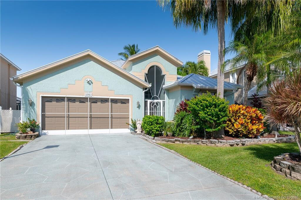 895 Northwest Sassafras Terrace Stuart, FL 34994 - Photo 1 of 23 a front view of a house with a yard and garage