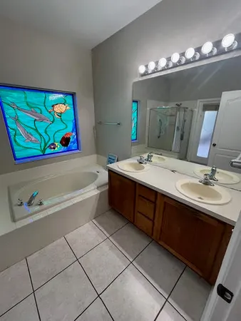 a bathroom with a sink a large mirror and a bathtub