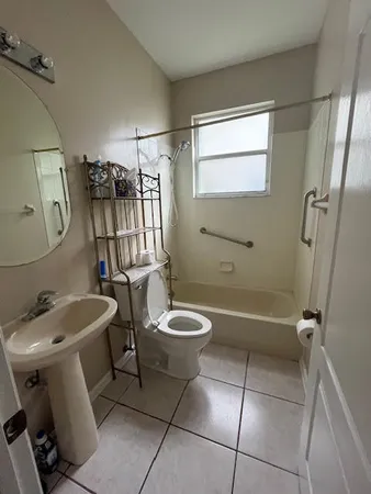 a bathroom with a toilet sink and mirror