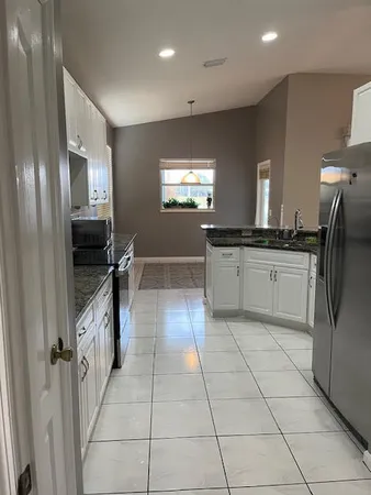 a kitchen with stainless steel appliances granite countertop a stove a sink and a refrigerator