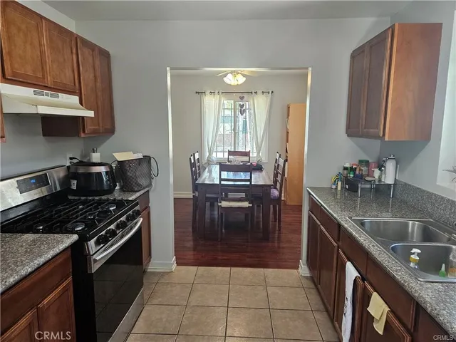 a kitchen with granite countertop a stove a sink and a microwave