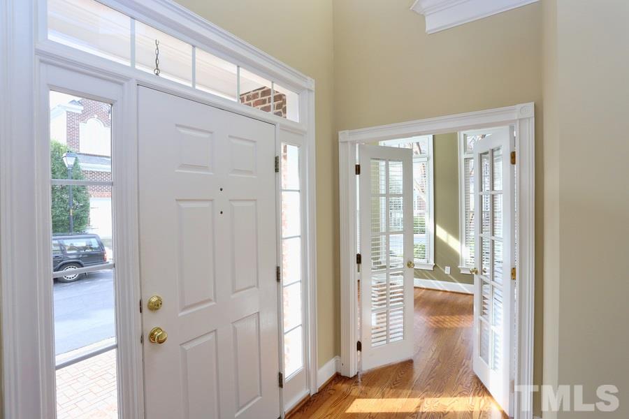 3109 Bentley Hill Road Raleigh, NC 27612 - Photo 2 of 25 a view of a hallway to a livingroom with wooden floor and windows
