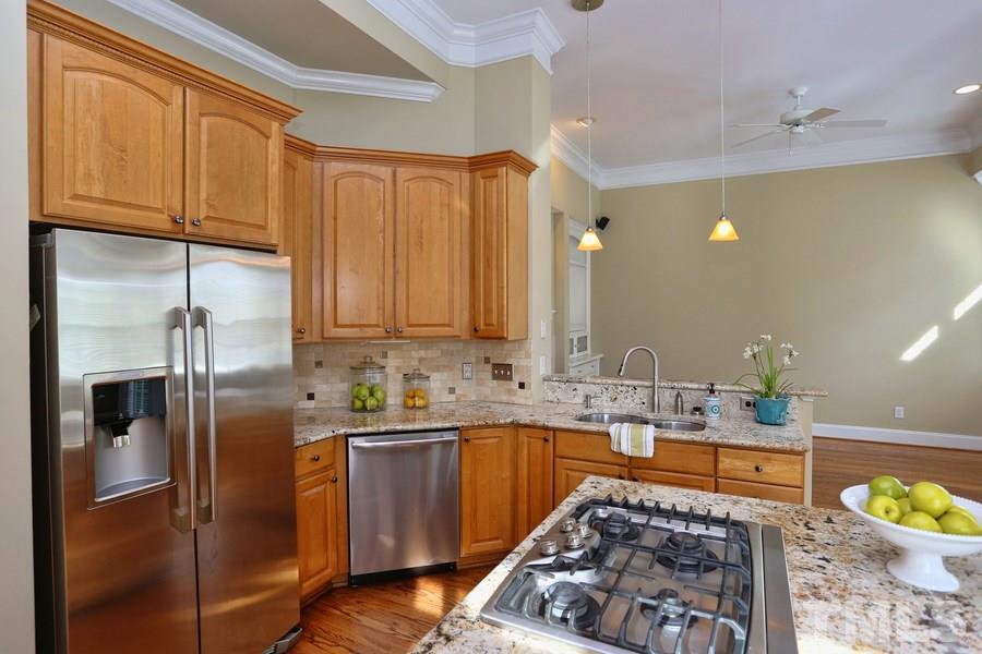 3109 Bentley Hill Road Raleigh, NC 27612 - Photo 10 of 25 a kitchen with stainless steel appliances a sink a stove a refrigerator cabinets and a window