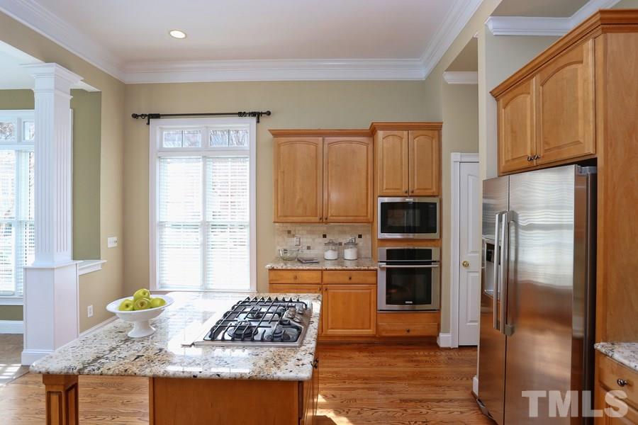 3109 Bentley Hill Road Raleigh, NC 27612 - Photo 11 of 25 a kitchen with granite countertop a refrigerator and a stove top oven