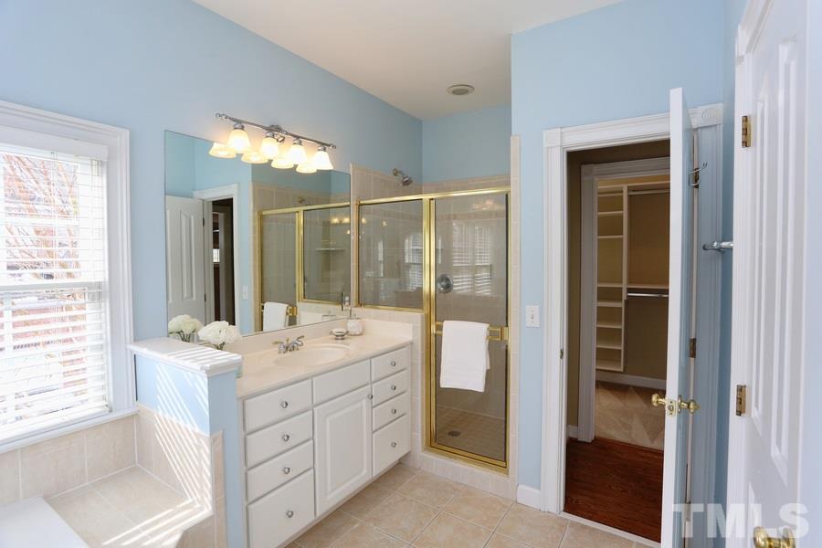 3109 Bentley Hill Road Raleigh, NC 27612 - Photo 17 of 25 a bathroom with a double vanity sink a mirror and a bathtub