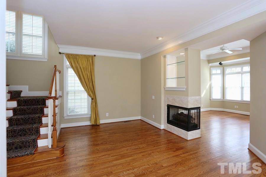3109 Bentley Hill Road Raleigh, NC 27612 - Photo 6 of 25 an empty room with wooden floor staircase and windows