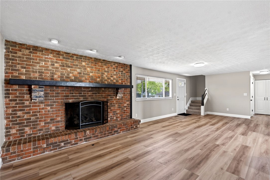 5975 Rosalie Road Dayton, OH 45424 - Photo 45 of 48 This inviting living area features a charming brick fireplace and durable hardwood flooring.