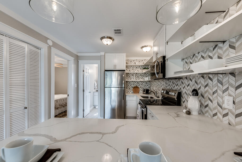 3799 East County Highway 30A, Unit C3 Santa Rosa Beach, FL 32459 - Photo 21 of 43 a kitchen with stainless steel appliances kitchen island granite countertop a refrigerator and a sink