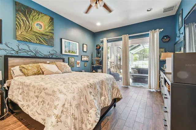 a bedroom with a bed dresser and a wooden floor