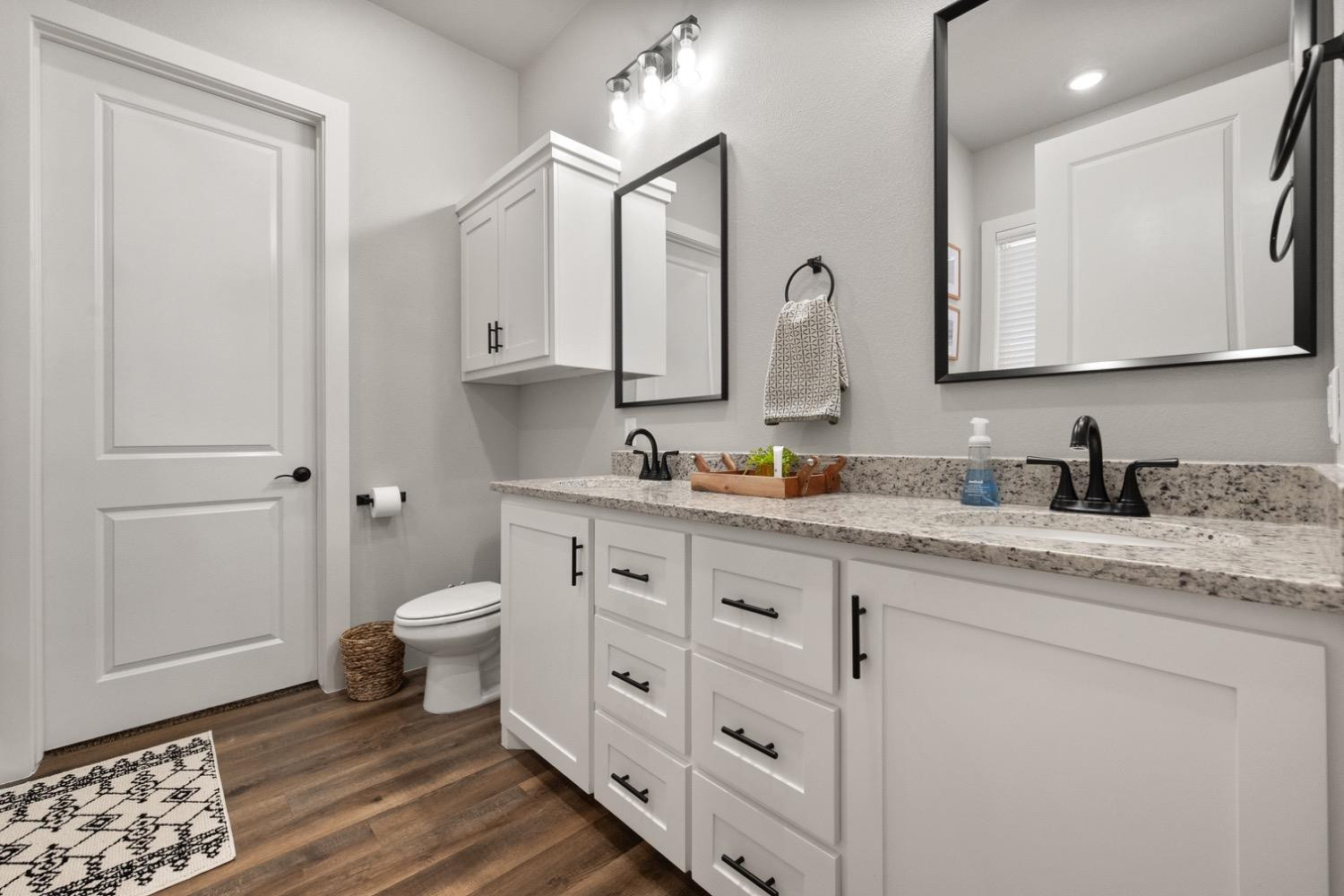 7805 52nd Street Lubbock, TX 79407 - Photo 21 of 32 a bathroom with a granite countertop toilet sink and mirror