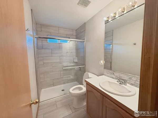 a bathroom with a sink toilet a mirror and shower