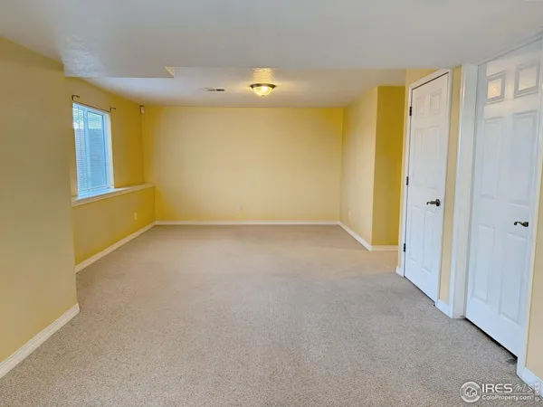 a view of a hallway with wooden floor and a bathroom